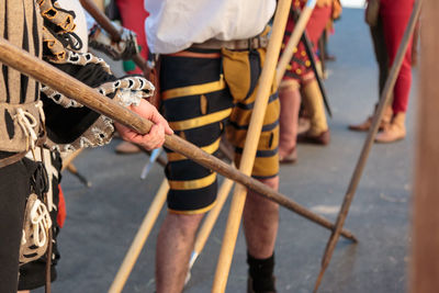 Low section of people standing with spear on road