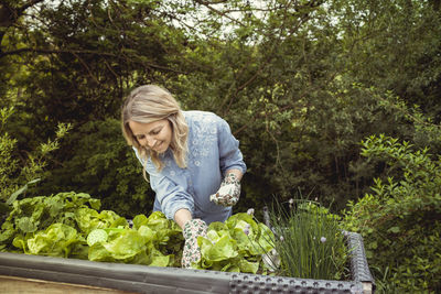 Woman wearing mask against plants