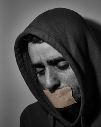 Close-up portrait of man wearing mask against gray background