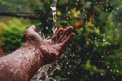 Close-up of water falling on hand