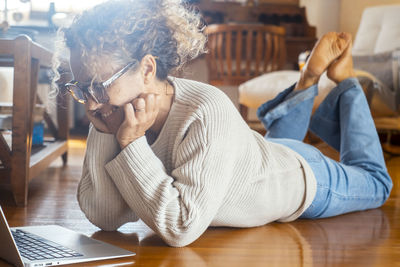 Side view of woman using digital tablet on table