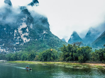 Scenic view of lake in forest against sky