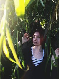 Portrait of woman standing by plants