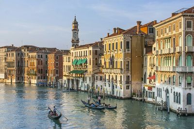 Gondolas on grand canal by buildings in city