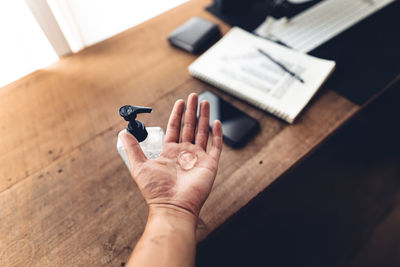 High angle view of woman hand on table