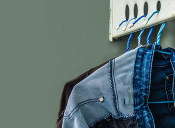 Close-up of clothes hanging on blue wall