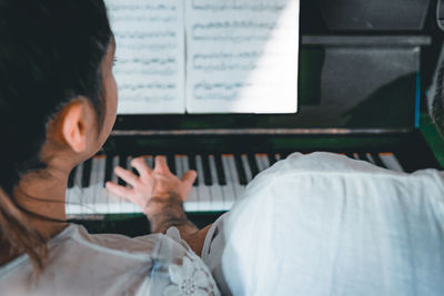 Rear view of man playing piano