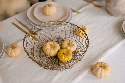 Small pumpkins in a wicker basket on the table for thanksgiving