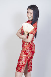 Woman holding red umbrella against white background