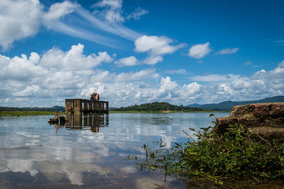 Scenic view of lake by building against sky