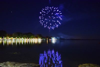 Firework display over river at night