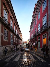 People on street amidst buildings in city