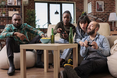 Friends using digital tablet while sitting at home