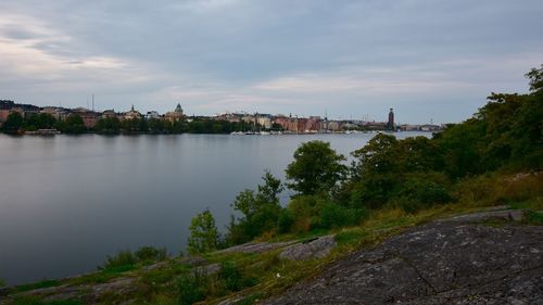 View of calm river against cloudy sky