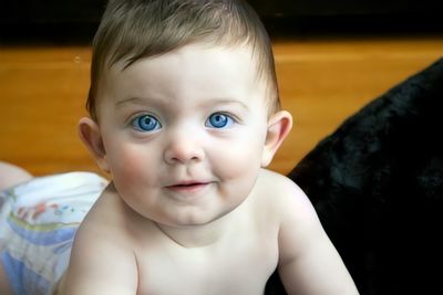 Baby with blue eyes and diape looks at camera at chatham, cape cod.