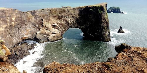 Rock formations by sea against sky