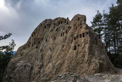 Low angle view of rock formation against sky