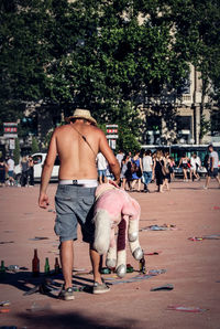 Rear view of shirtless man with arms outstretched