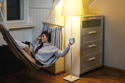 Rear view of woman sitting on table