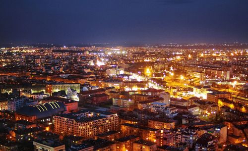 High angle view of illuminated city buildings against clear sky