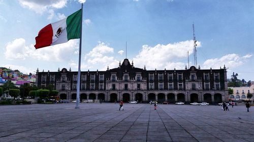 Flag by built structure against sky