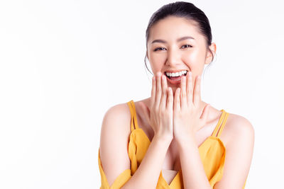 Portrait of smiling young woman against white background