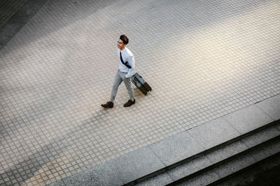 High angle view of young man walking on zebra crossing