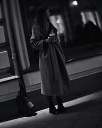 Rear view of woman standing on escalator