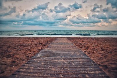 Surface level of empty beach against sky