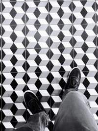 Low section of man standing on tiled floor