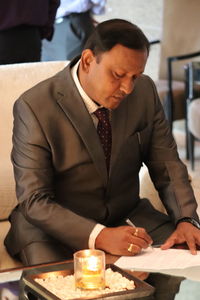 Mid adult man looking at camera on table