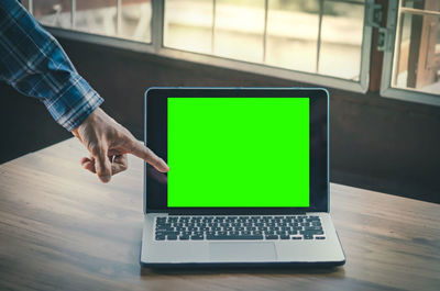 Midsection of man using laptop on table