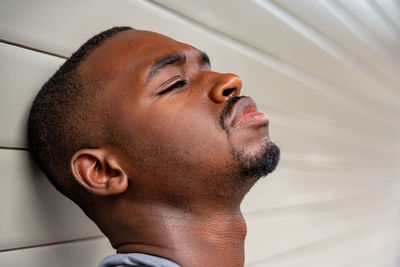 Close-up of young man against wall