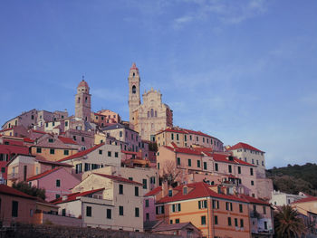 Buildings in town against blue sky