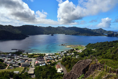 High angle view of city by sea against sky