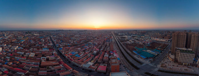 High angle view of illuminated cityscape against sky during sunset