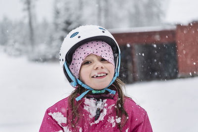 Portrait of smiling girl wearing helmet in winter