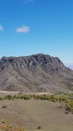 Scenic view of rocky mountains against blue sky