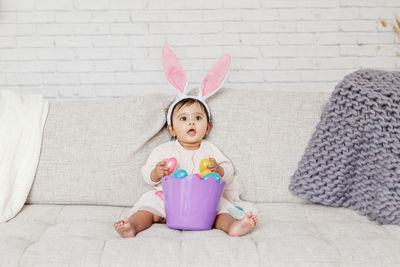 Cute girl wearing costume sitting on sofa