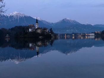 Scenic view of lake by snowcapped mountains against sky