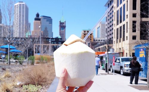 Hand holding ice cream in city