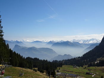 Scenic view of mountains against blue sky