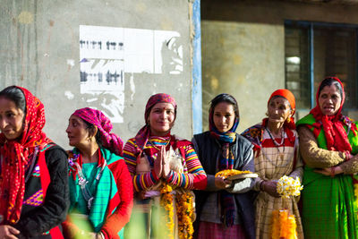 Portrait of friends standing against the wall