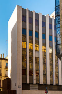 Low angle view of modern building against blue sky