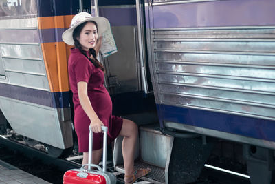 Portrait of woman standing on railroad station