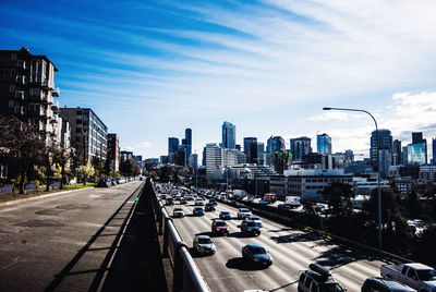 Traffic on road in city against sky