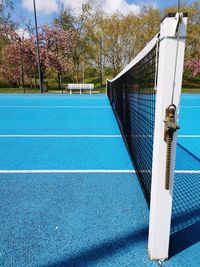 Empty benches on field against blue sky