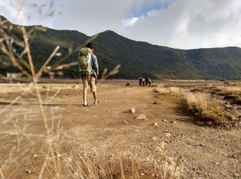 Man walking on landscape against mountains