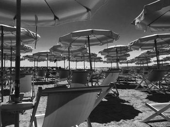 Chairs and tables at restaurant against sky