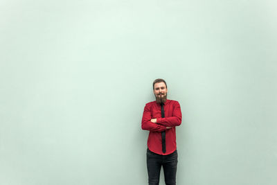 Portrait of young man standing against wall